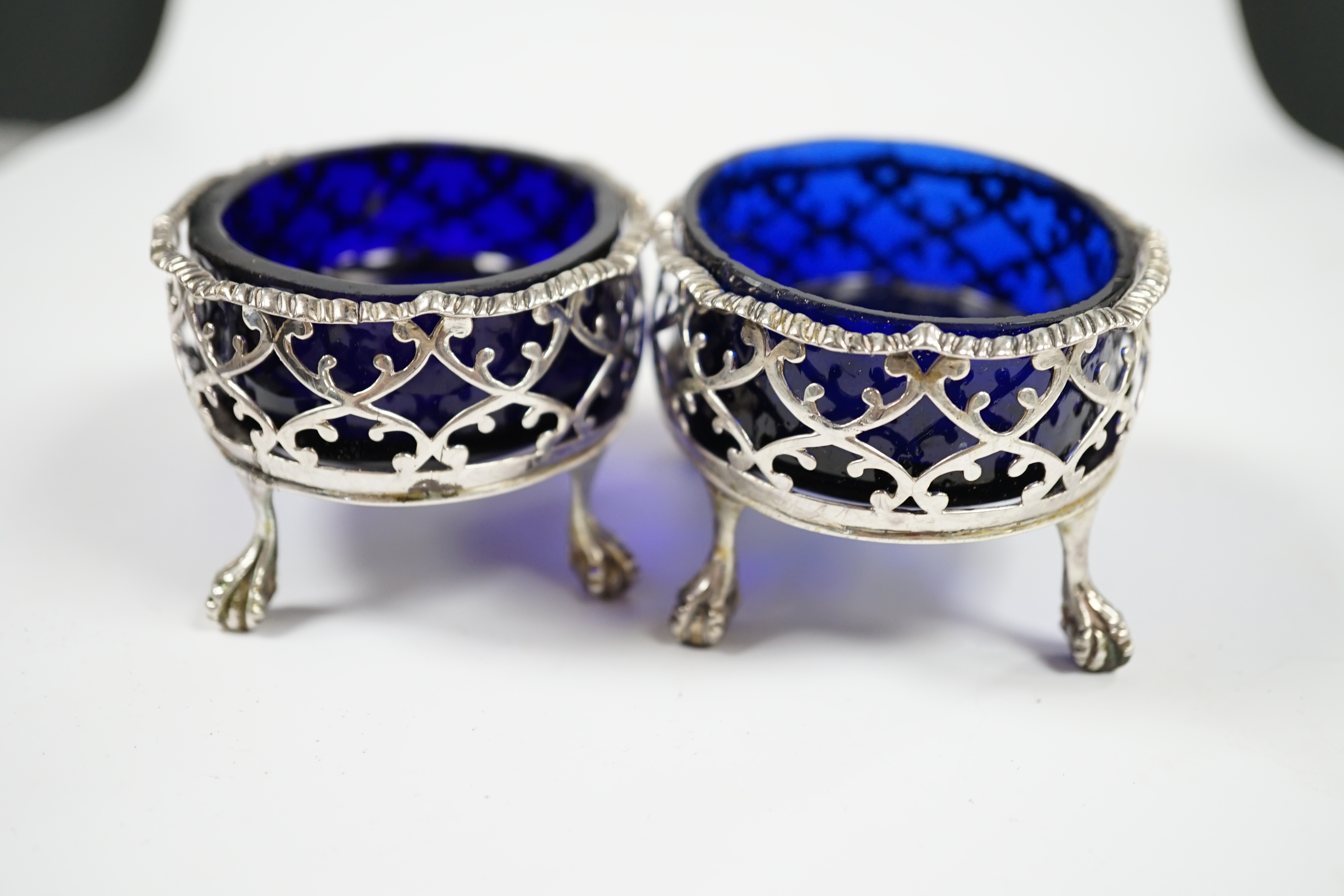 A pair of late George II pierced silver oval salts, by Robert & David Hennell I, London, 1759, with associated blue glass liners, 83mm. Condition - poor